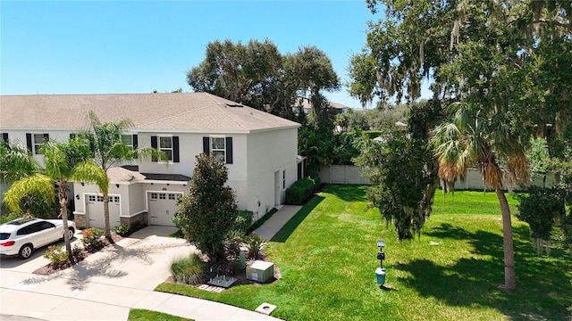 exterior space featuring fence, a garage, concrete driveway, a front yard, and stucco siding
