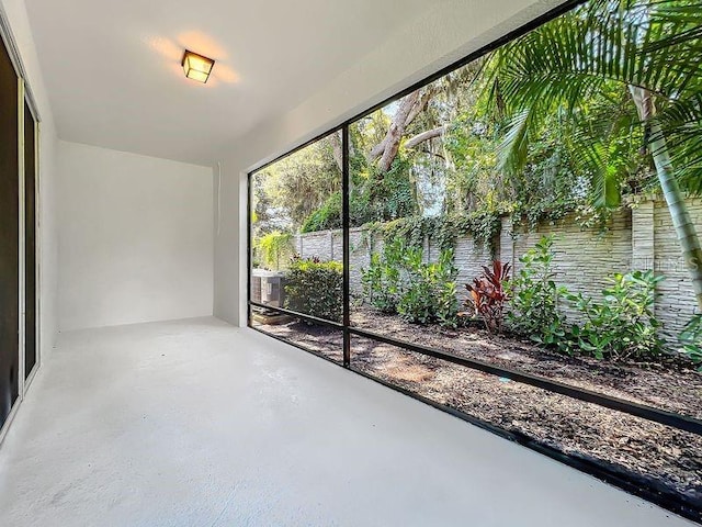 unfurnished sunroom featuring concrete flooring