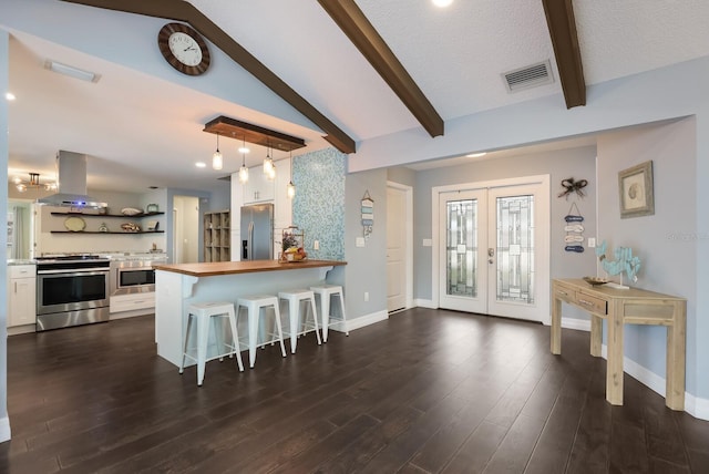 kitchen featuring appliances with stainless steel finishes, kitchen peninsula, a breakfast bar area, and dark hardwood / wood-style floors