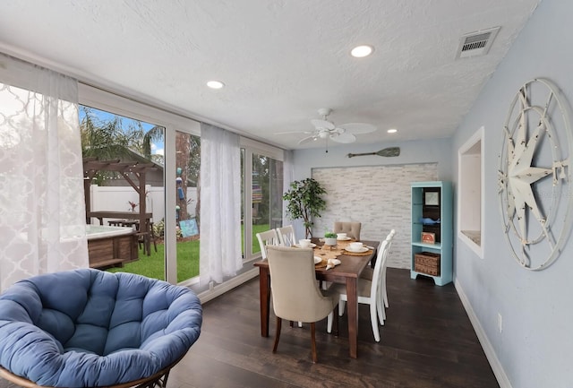 dining space featuring a textured ceiling, plenty of natural light, ceiling fan, and dark wood-type flooring