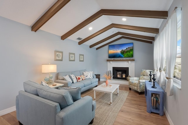 living room featuring light hardwood / wood-style flooring and vaulted ceiling with beams