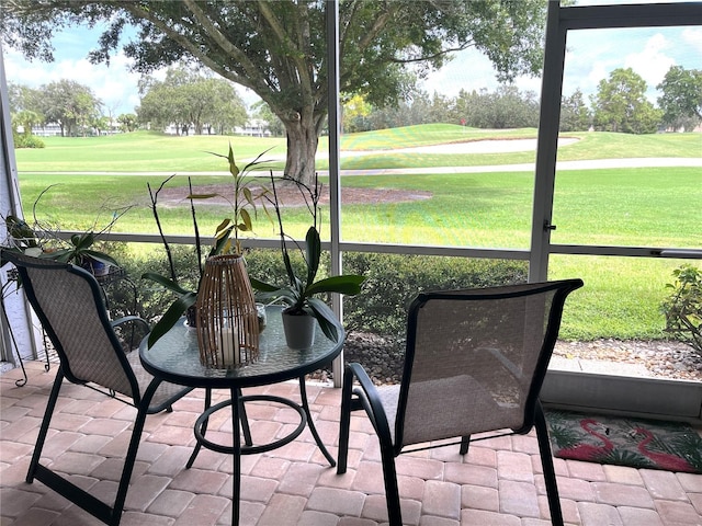 sunroom / solarium featuring view of golf course and a healthy amount of sunlight