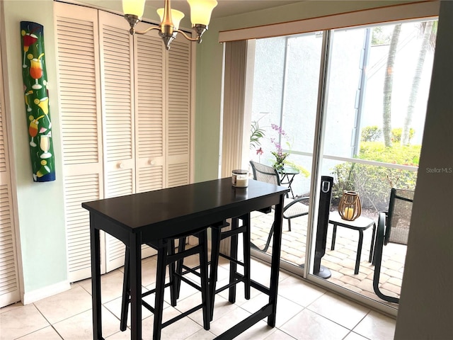 dining room with light tile patterned flooring, baseboards, and a chandelier