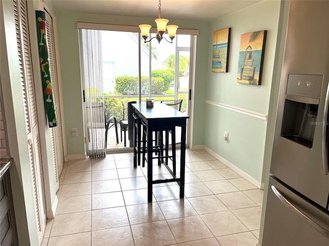 dining room with light tile patterned flooring, baseboards, and a chandelier