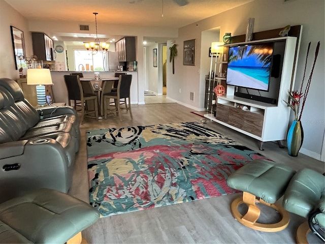 living area featuring a notable chandelier, visible vents, and baseboards