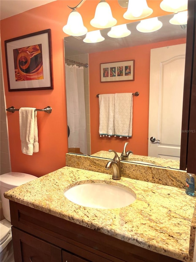 bathroom with vanity, curtained shower, and toilet