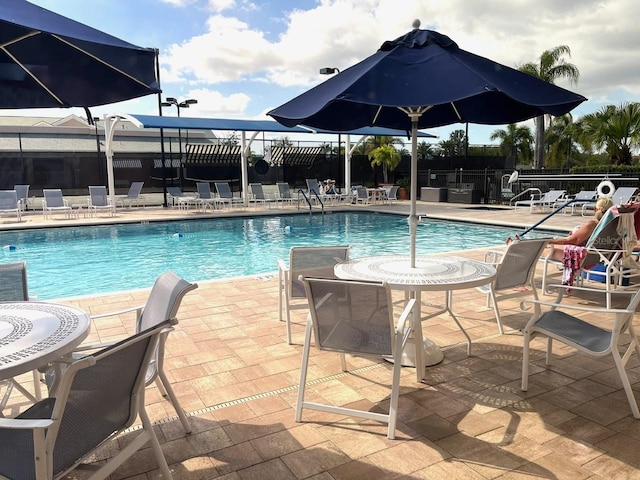 pool with a patio area and fence