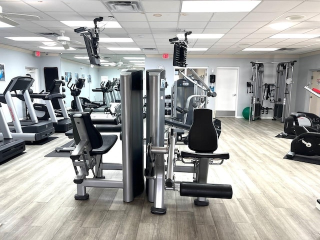 gym featuring visible vents, ceiling fan, a drop ceiling, ornamental molding, and wood finished floors