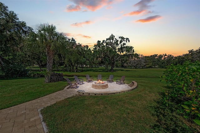 yard at dusk featuring an outdoor fire pit