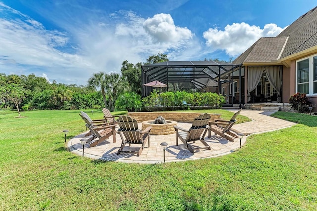 view of yard featuring a patio area, glass enclosure, and an outdoor fire pit