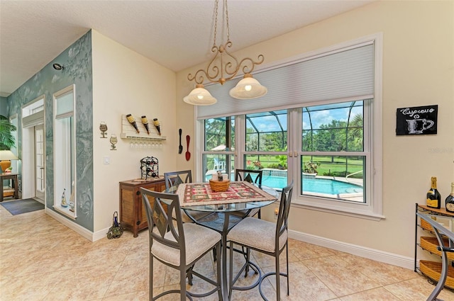 tiled dining space featuring a textured ceiling and a healthy amount of sunlight