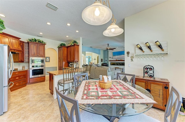 tiled dining area featuring a textured ceiling and ceiling fan