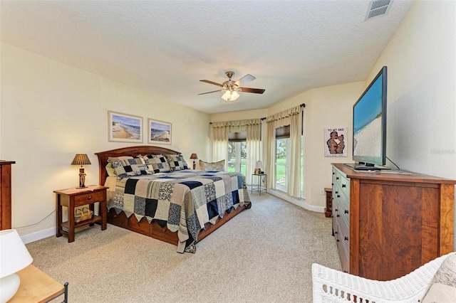 carpeted bedroom featuring a textured ceiling and ceiling fan