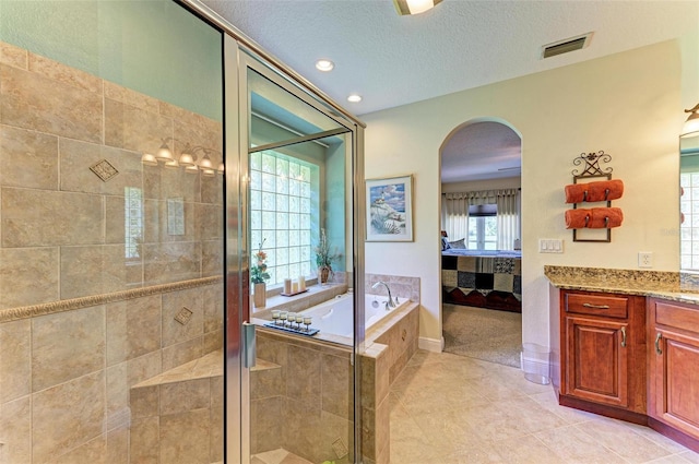 bathroom with vanity, a textured ceiling, separate shower and tub, and tile patterned floors