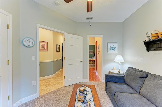 carpeted living room with a textured ceiling and ceiling fan