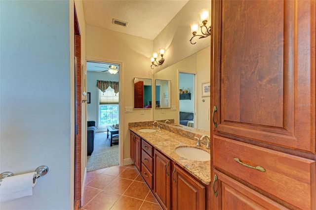 bathroom with vanity, a textured ceiling, ceiling fan, and tile patterned floors