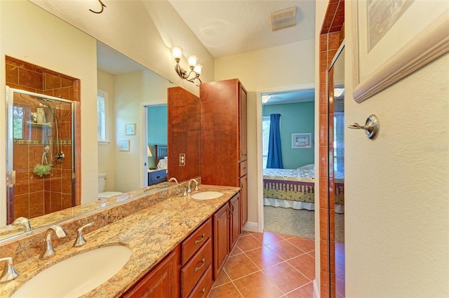 bathroom with toilet, tile patterned flooring, vanity, a textured ceiling, and a shower with shower door