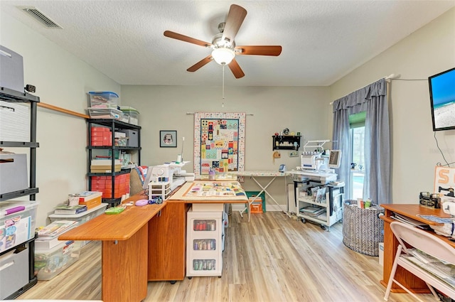 office featuring a textured ceiling, light hardwood / wood-style flooring, and ceiling fan