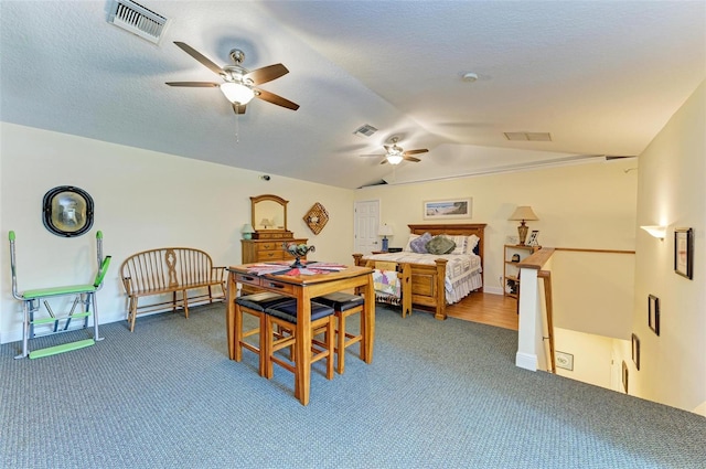 dining room with hardwood / wood-style floors, ceiling fan, a textured ceiling, and vaulted ceiling