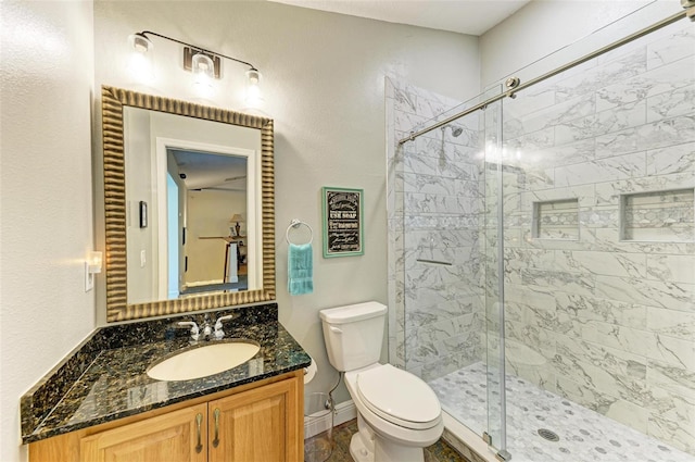 bathroom with vanity, toilet, and a shower with door