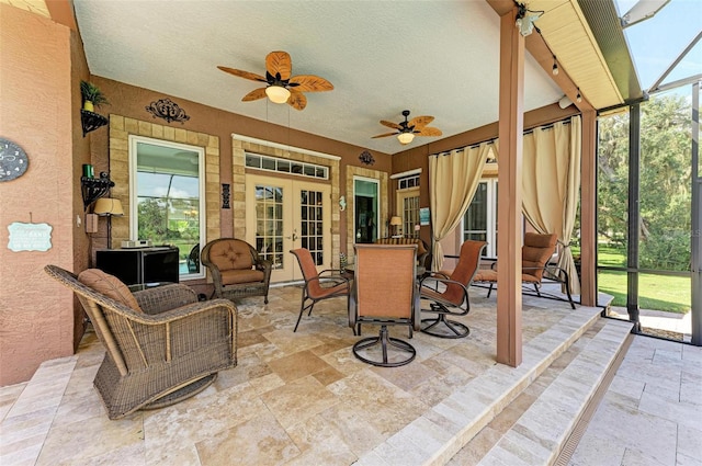 sunroom / solarium with plenty of natural light, ceiling fan, and french doors