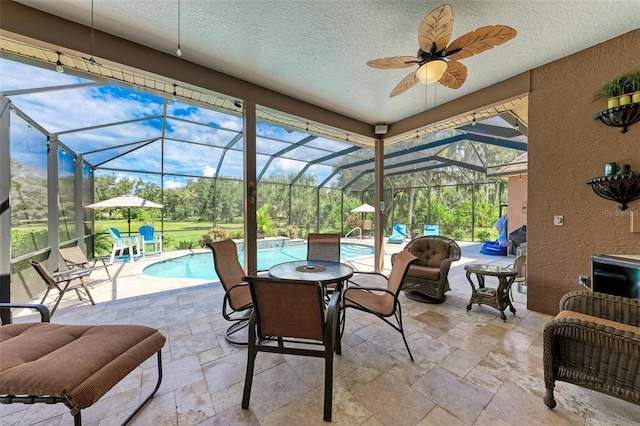 sunroom / solarium featuring a wealth of natural light, ceiling fan, and a pool