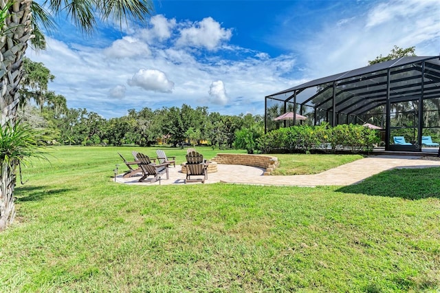 view of yard featuring a lanai, a fire pit, and a patio area