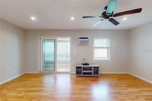 empty room with light hardwood / wood-style floors, ceiling fan, and a wall mounted air conditioner