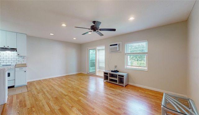 unfurnished living room with ceiling fan, light hardwood / wood-style floors, and a wall mounted AC