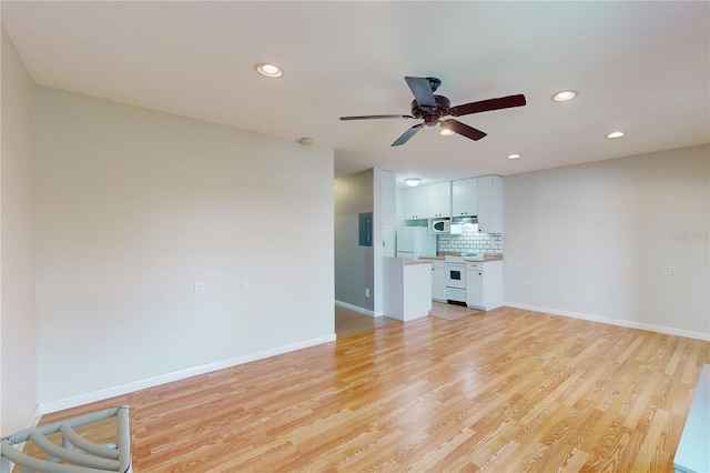 unfurnished living room featuring light hardwood / wood-style floors, electric panel, and ceiling fan