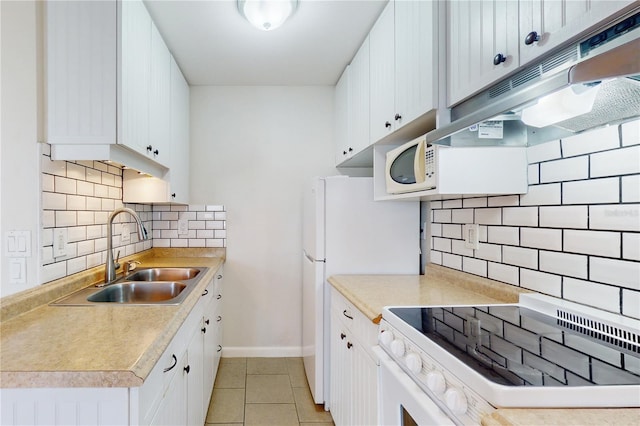 kitchen with light tile patterned flooring, sink, range, white cabinetry, and decorative backsplash