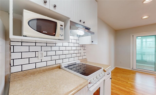 kitchen with light hardwood / wood-style floors, tasteful backsplash, white cabinets, stove, and exhaust hood