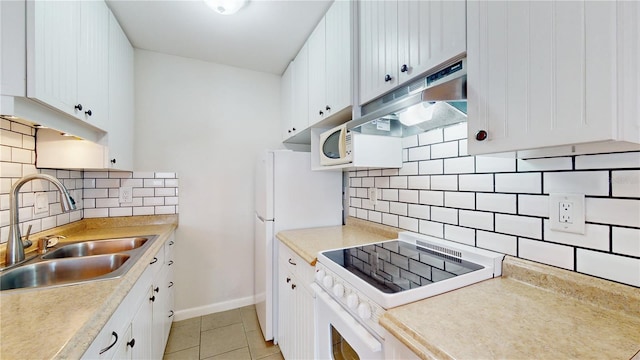 kitchen with tasteful backsplash, sink, white cabinets, stove, and light tile patterned floors