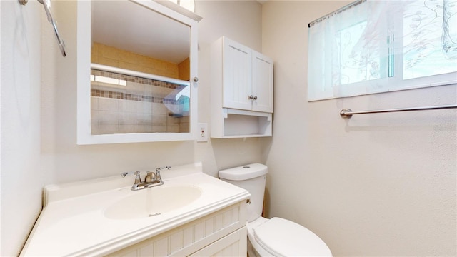 bathroom with a shower with door, vanity, and toilet