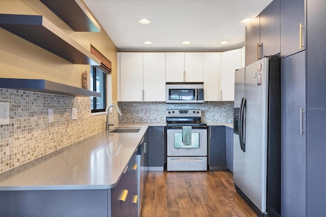 kitchen featuring white cabinets, appliances with stainless steel finishes, dark hardwood / wood-style flooring, sink, and decorative backsplash