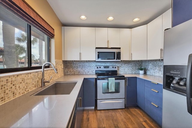 kitchen with blue cabinetry, stainless steel appliances, dark hardwood / wood-style flooring, white cabinetry, and sink