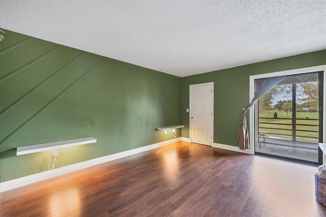 unfurnished room featuring a textured ceiling and dark hardwood / wood-style flooring