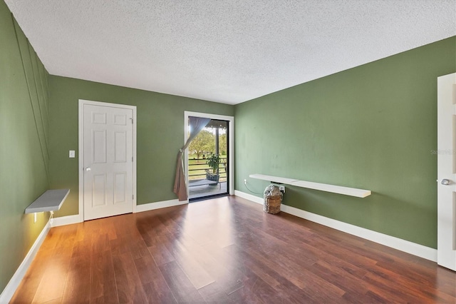 empty room featuring a textured ceiling and hardwood / wood-style floors