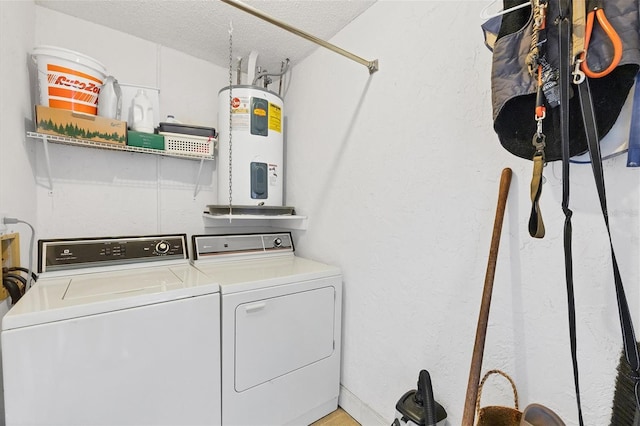 washroom with a textured ceiling, water heater, and washer and dryer