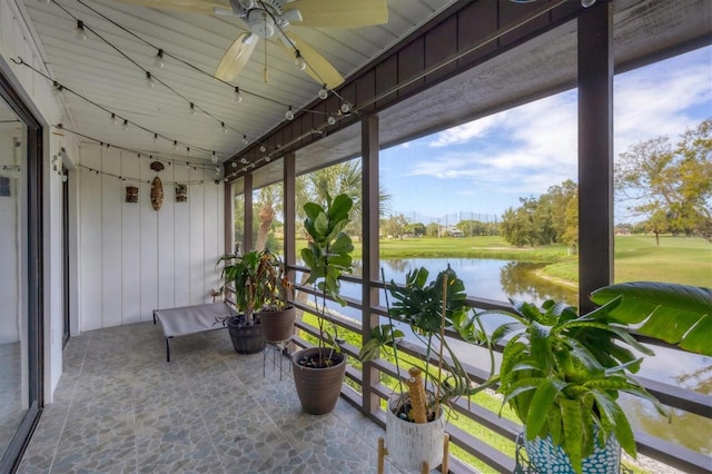 sunroom / solarium with ceiling fan and a water view