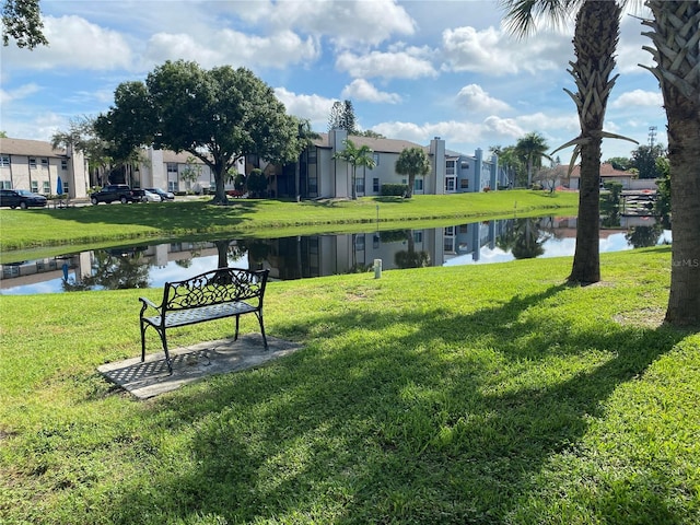 surrounding community with a yard and a water view