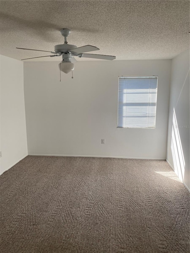 unfurnished room featuring carpet flooring, ceiling fan, and a textured ceiling