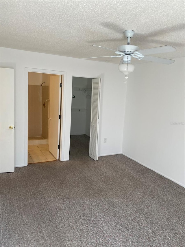 carpeted spare room with ceiling fan and a textured ceiling