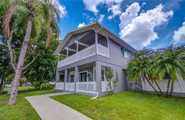 exterior space with a lawn, a porch, and a balcony