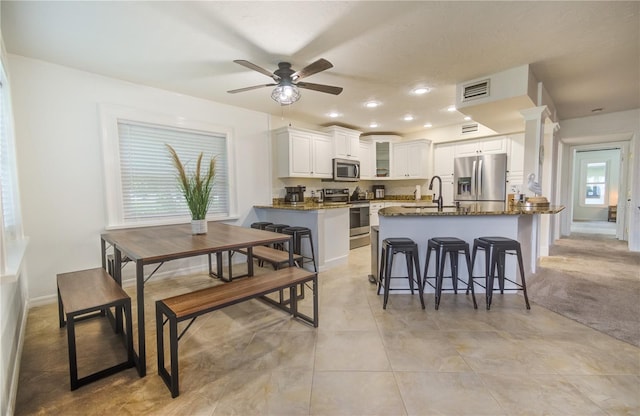 dining space featuring ceiling fan, light tile patterned flooring, and sink