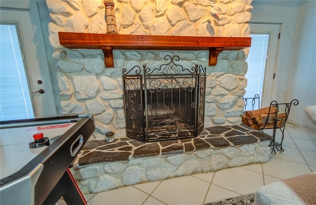 interior details with tile patterned flooring and a stone fireplace