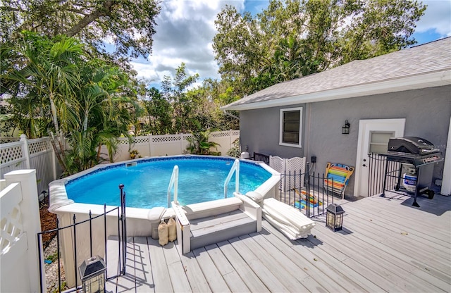 view of pool with area for grilling and a wooden deck