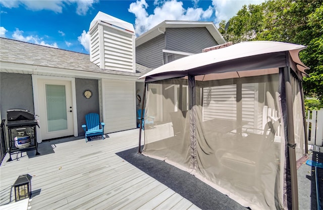 wooden deck featuring area for grilling and a gazebo