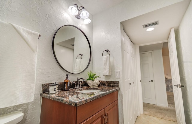 bathroom with vanity, toilet, and tile patterned floors