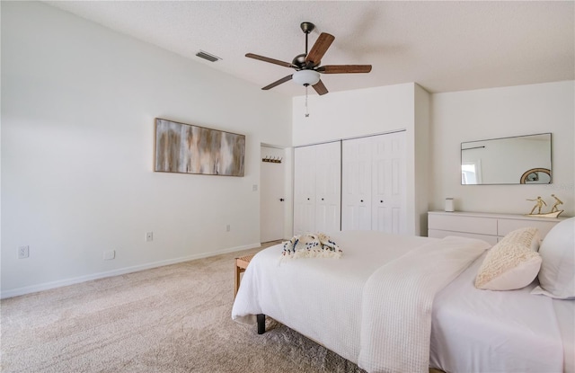 bedroom featuring a textured ceiling, carpet, ceiling fan, and a closet